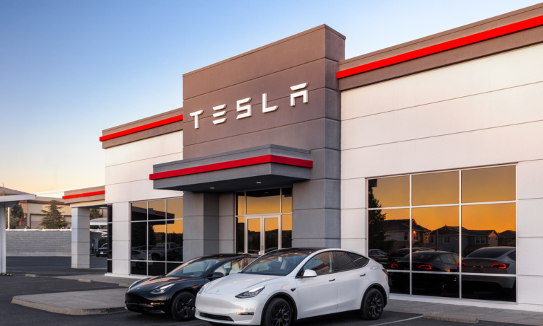 1714404659 tesla building with tesla logo and two teslas in front