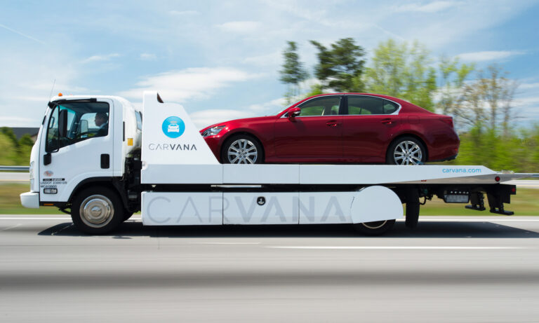car on carvana delivery truck with logo carvana