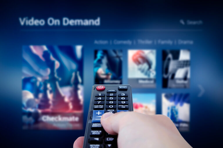 right hand holding remote streaming tv