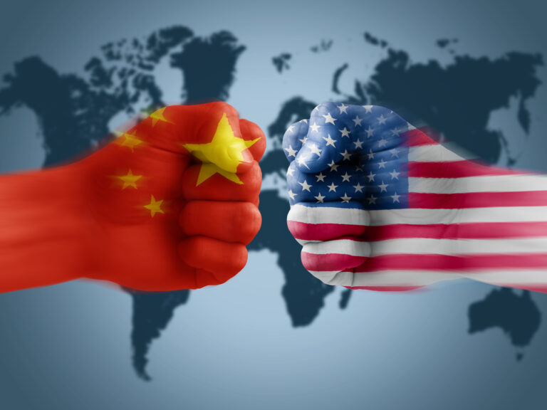 two fists meet one emblazoned with chinese flag and one with us flag