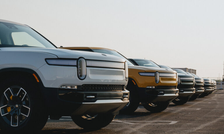 line of rivian trucks in parking lot rivian