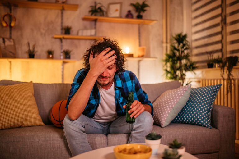 man looks upset while sitting on a couch