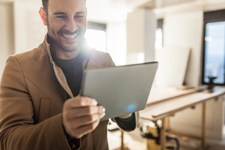 person smiling while looking at a tablet