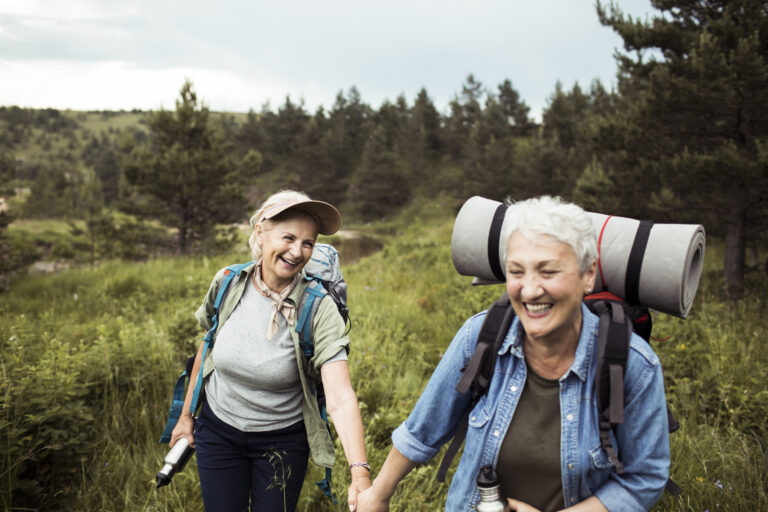 two older people outside hiking