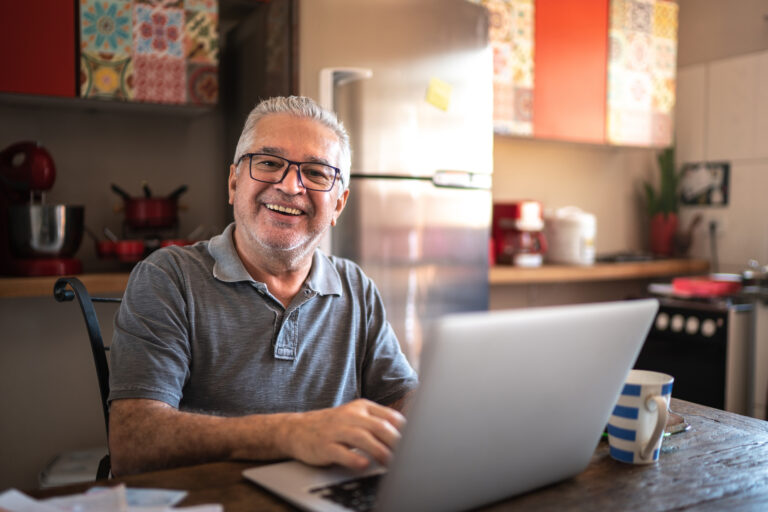 older man laptop smiling gettyimages 1278322389