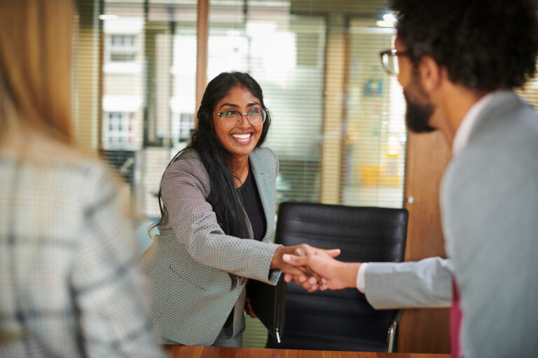 people shaking hands making a deal in an office