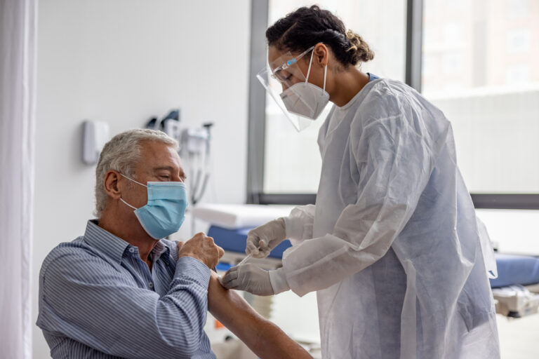 nurse vaccinating elderly patient